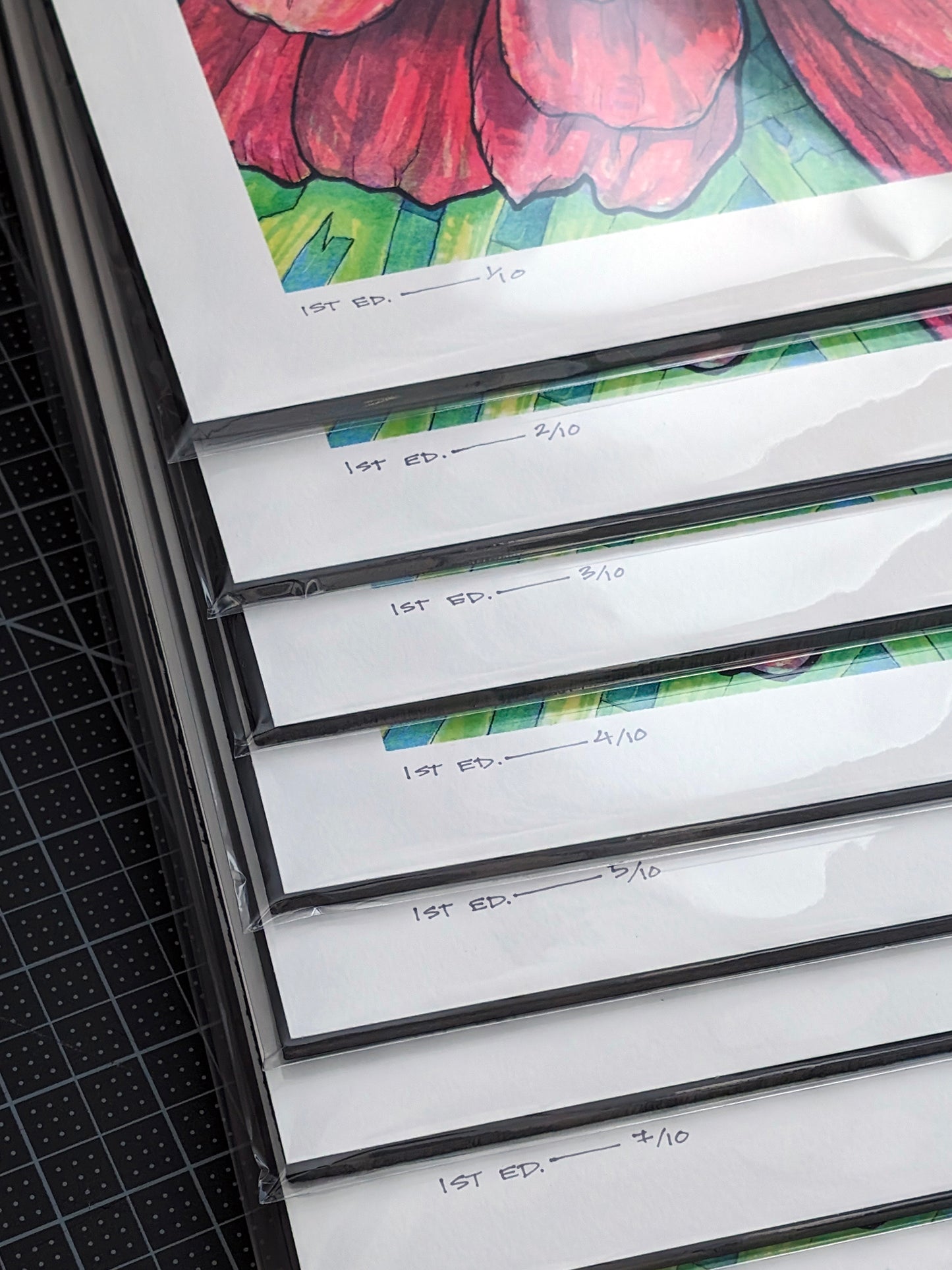 This is a photo showing a stack of hand-numbered limited editions art prints. The original artwork was created with india ink on watercolor paper by artist Katy V. Meehan. These are prints of a hand painted rendering of a flower. The artwork is titled, ‘State Fair Zinnia’.